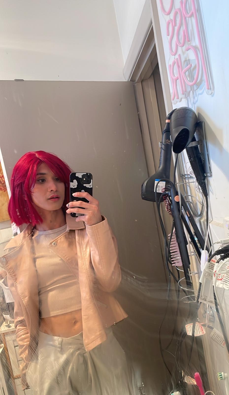 POR$CHA with red hair in beige, tilted mirror self-portrait