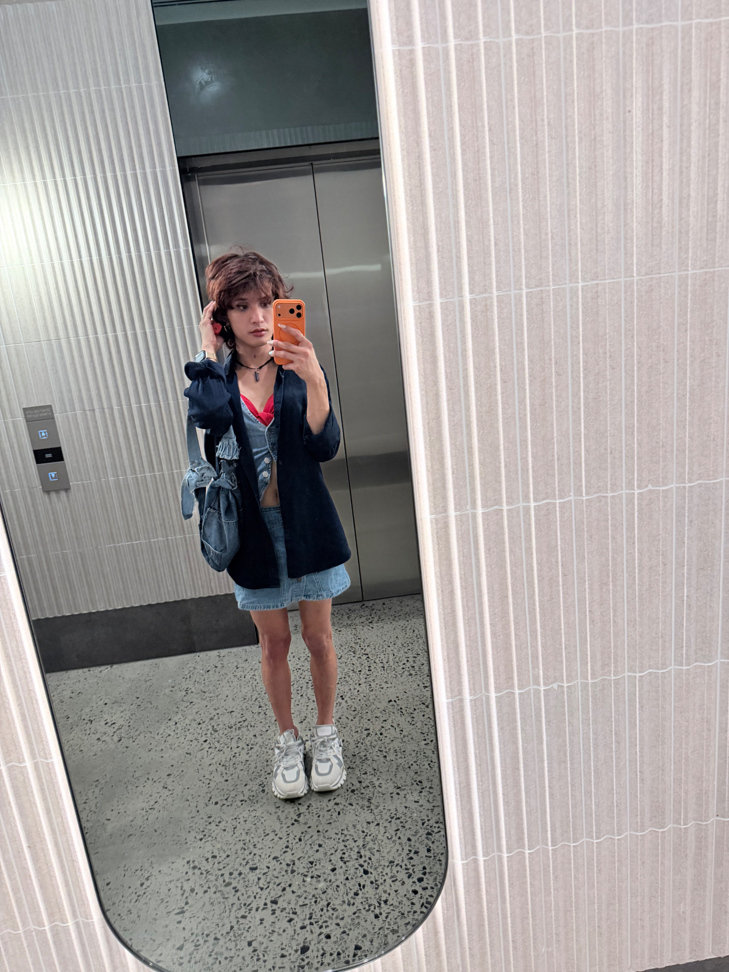 POR$CHA in denim and sneakers, elevator mirror self-portrait