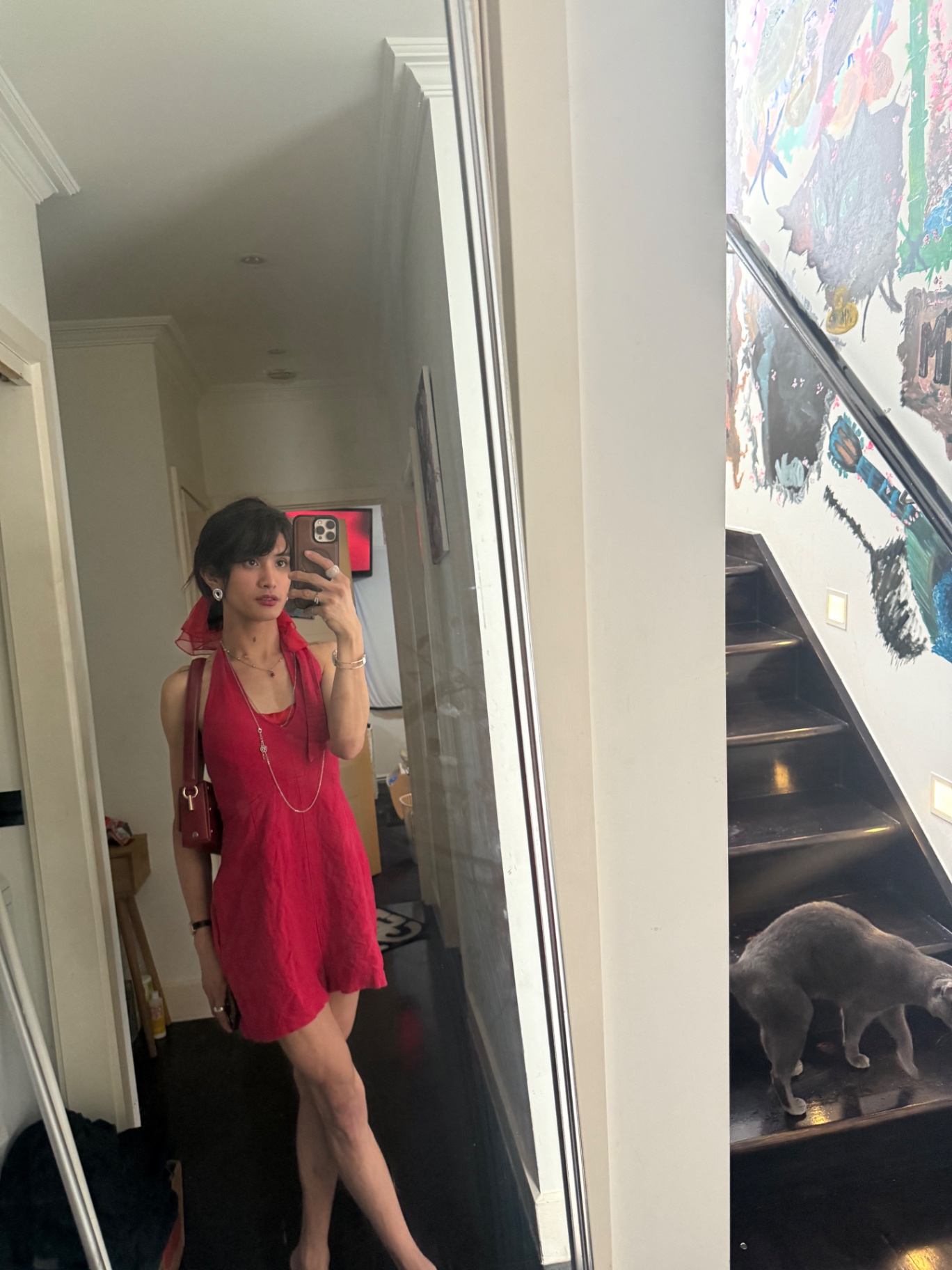 POR$CHA in red beside a staircase, mirror self-portrait