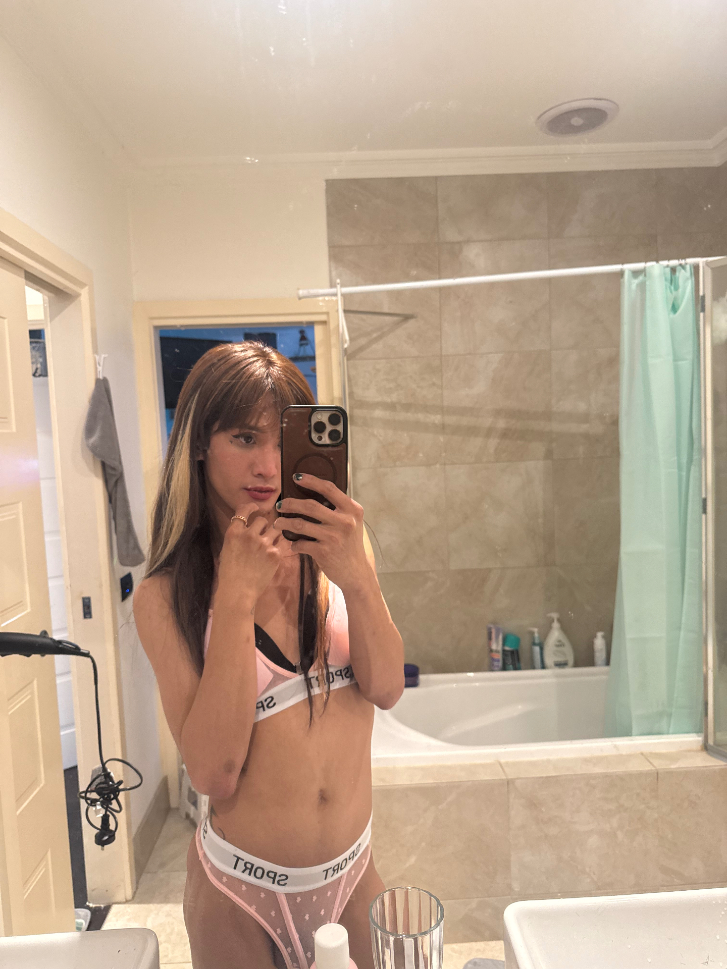POR$CHA in pink-and-white lingerie, bathroom mirror self-portrait