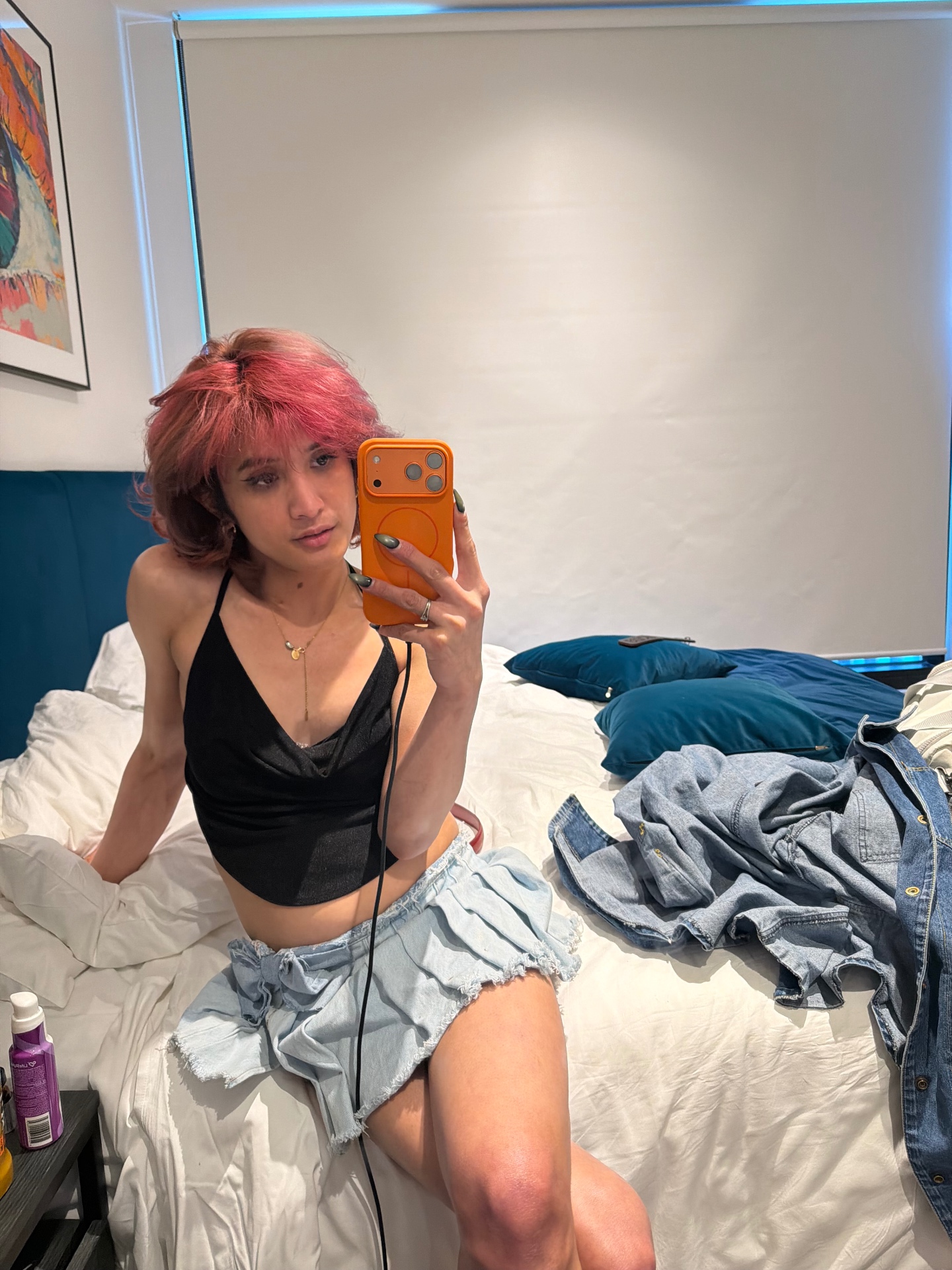 POR$CHA with pink hair in black top and denim skirt, mirror self-portrait