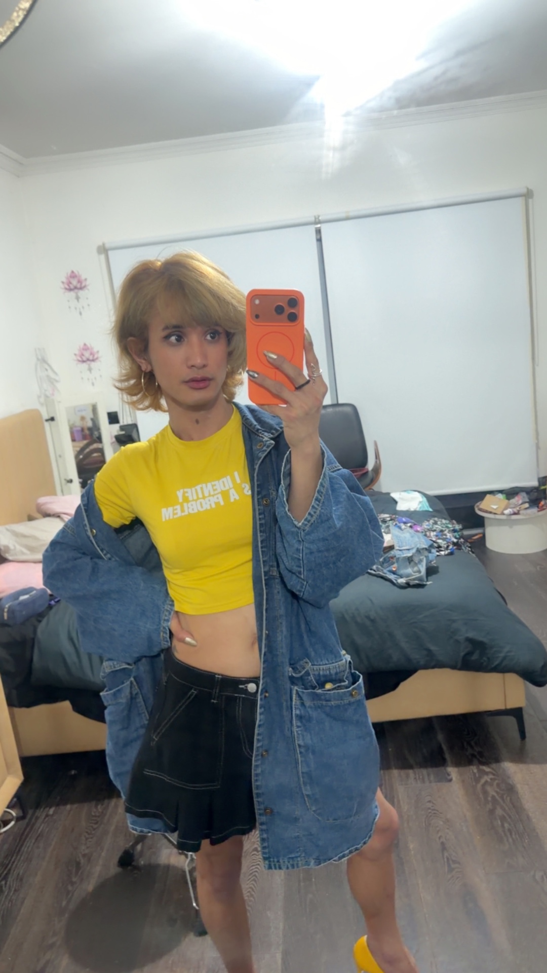 POR$CHA in yellow top and denim jacket, mirror self-portrait