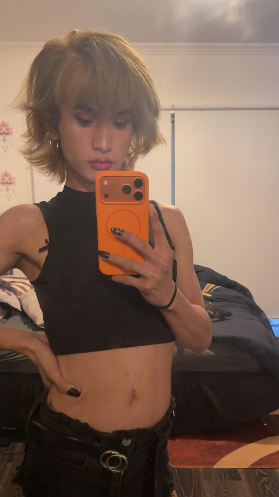 Close mirror self-portrait of POR$CHA in black with short blonde hair