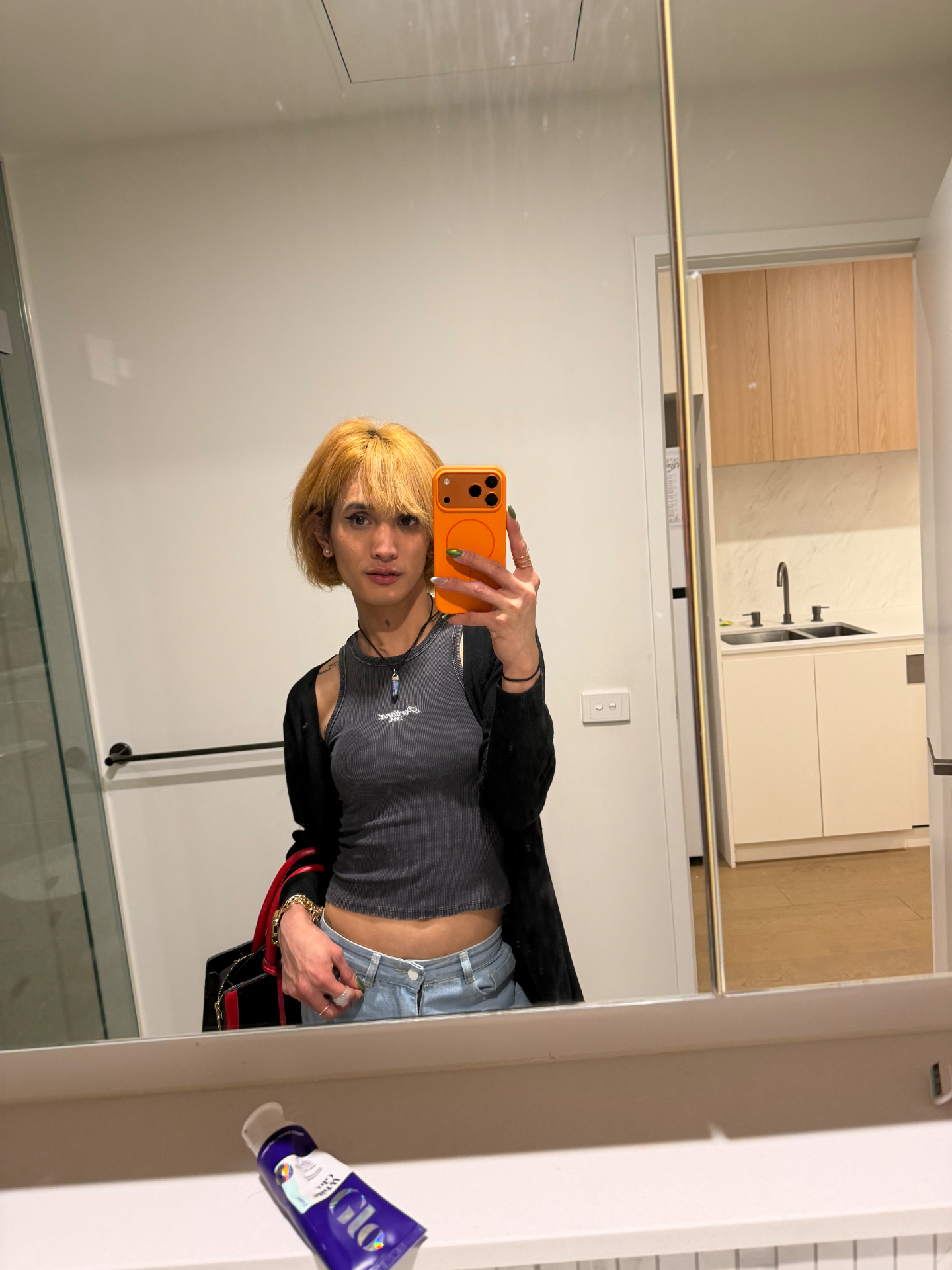 POR$CHA in a grey top and denim, bathroom mirror self-portrait